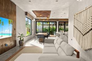 a living room with a white couch and a table at Piedras Luxe by Prestigia - Villa in Tulum