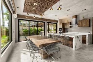 a kitchen with a large wooden table and chairs at Piedras Luxe by Prestigia - Villa in Tulum
