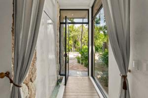 an open door to a room with sliding glass doors at Piedras Luxe by Prestigia - Villa in Tulum +65 photos