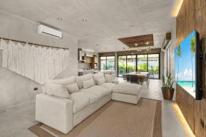 a living room with a white couch and a table at Twin Luxury Villas - Groups Prstigia MX in Tulum
