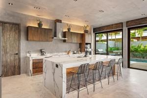 a kitchen with a large island with bar stools at Twin Luxury Villas - Groups Prstigia MX in Tulum