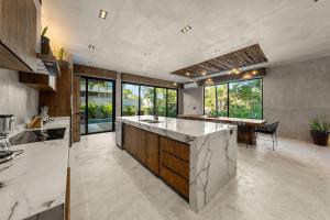 a kitchen with a large island in the middle at Twin Luxury Villas - Groups Prstigia MX in Tulum +39 photos