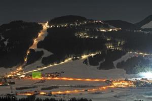 a ski resort at night with lights in the snow at Hotel Ritterhof Ellmau in Ellmau +88 photos
