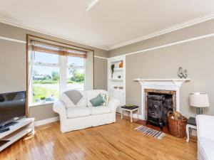 a living room with a white couch and a fireplace at The Laurels in Nairn