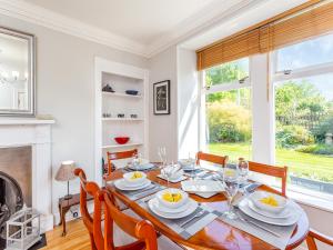 a dining room with a table and chairs and a fireplace at The Laurels in Nairn