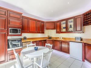 a kitchen with wooden cabinets and a white table and chairs at The Laurels in Nairn