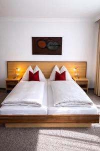 ein Schlafzimmer mit einem großen Bett und roten Kissen in der Unterkunft Hotel Sommerer - Hike & Bike in Saalbach, Joker Card inkl in Saalbach-Hinterglemm + 18 Fotos