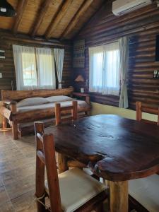 a room with a wooden table and two beds at Alma de Algarrobo in San Javier