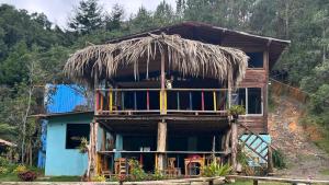a house with a thatched roof and a staircase at Casa Aurea in Medellín