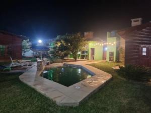 a backyard with a swimming pool at night at Cabañas Donato in Colonia Benítez