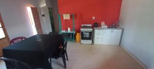 a kitchen with a black table and a red wall at Cabañas Donato in Colonia Benítez +5 photos