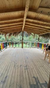 a large wooden deck with chairs and a wooden ceiling at Casa Aurea in Medellín