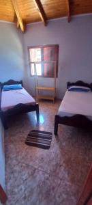 a room with two beds and a window at Cabañas Donato in Colonia Benítez