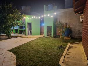 a house with a green facade at night at Cabañas Donato in Colonia Benítez
