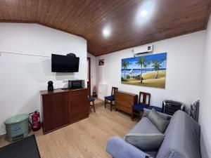 a living room with a couch and a flat screen tv at Gerês Natura in Valdosende