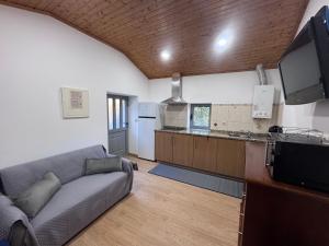 a living room with a couch and a kitchen at Gerês Natura in Valdosende