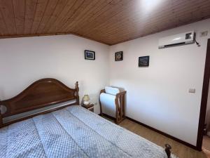 a bedroom with a bed and a wooden ceiling at Gerês Natura in Valdosende