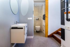 a small bathroom with a sink and a toilet at BaruHaus triplex piscina y parking in Villamañán +13 photos