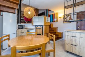 a kitchen and dining room with a wooden table and chairs at BaruHaus triplex piscina y parking in Villamañán