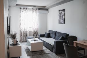 a living room with a blue couch and a table at Apartman Centar in Doboj +41 photos