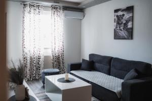 a living room with a blue couch and a table at Apartman Centar in Doboj