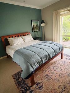 a bed in a bedroom with a green wall at Roses Farmhouse in Heathmere