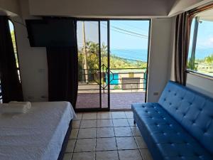 a bedroom with a bed and a view of the ocean at Hotel Manuel Antonio Beracha in Quepos