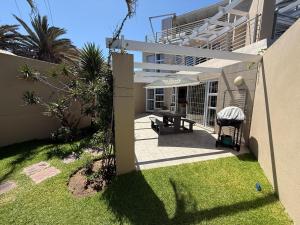 a patio with a table and a bench in a yard at Sand And Sea Self Catering #3 in Swakopmund