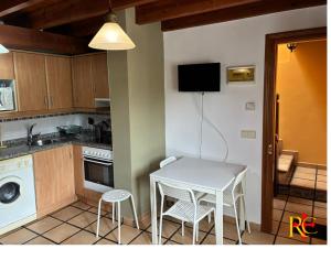a small kitchen with a white table and chairs at rincón de covadonga in Caño +9 photos