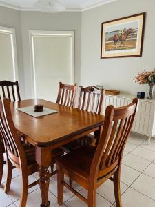 a dining room with a wooden table and chairs at Roses Farmhouse in Heathmere