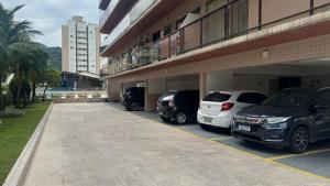 a group of cars parked in a parking lot at Costa Suite Enseada in Guarujá