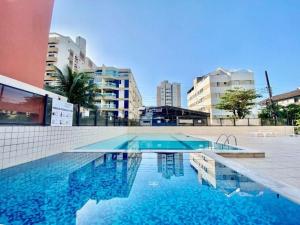 a swimming pool in the middle of a building at Costa Suite Enseada in Guarujá