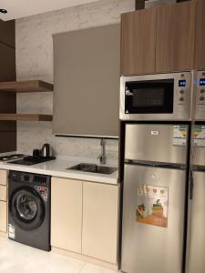 a kitchen with a refrigerator and a microwave at Pure Stay House in Taif
