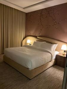 a bedroom with a large bed and two lamps at Pure Stay House in Taif