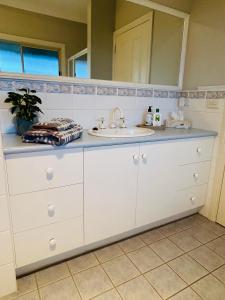 a bathroom counter with a sink and a mirror at Roses Farmhouse in Heathmere