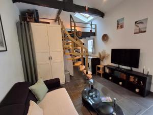 a living room with a couch and a staircase at Studio indépendant avec jardinet in Tarnos