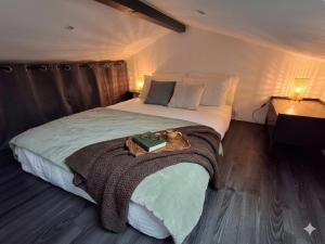 a bedroom with a large bed with a tray on it at Studio indépendant avec jardinet in Tarnos