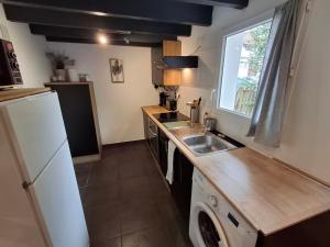 a kitchen with a white refrigerator and a sink at Studio indépendant avec jardinet in Tarnos +2 photos