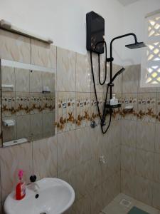 a bathroom with a sink and a mirror at Catwalk Factory Apartment in Ukunda