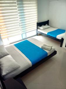 two beds in a room with a window at Hotel Colombia - Apulo in Apulo