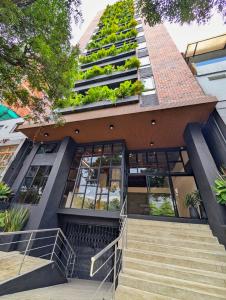 an apartment building with a green roof at Laureles Selection Suites in Medellín