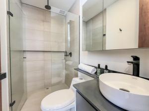 a white bathroom with a sink and a toilet at Upscale 2BR Countryside Suite | Stylish & Modern in El Retiro +36 photos
