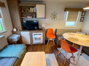 a small living room with a table and a tv at Jazmine's Place in Ayr