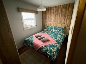 a small bedroom with a bed with towels on it at Jazmine's Place in Ayr