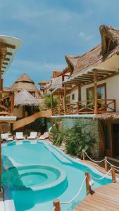 a large swimming pool in front of a house at Casa Las Tortugas Petit Beach Hotel & Spa in Holbox Island