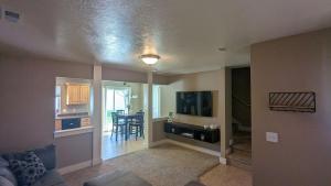 a living room with a couch and a tv and a kitchen at Central Mountain Retreat - Sleeps 7! in Logan