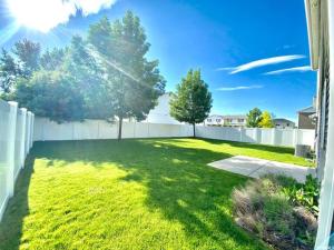 a backyard with a fence and a yard with trees at Central Mountain Retreat - Sleeps 7! in Logan