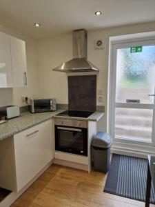 a kitchen with a stove top oven next to a window at Cosynitebnb for 4 in Birmingham