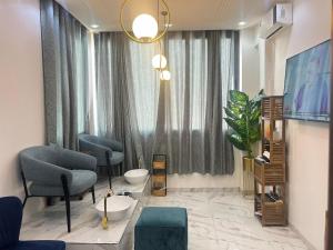 a living room with a chair and a window at Hôtel NGOR ALMADIES 4 étoiles in Dakar