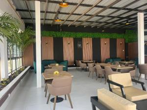 a restaurant with tables and chairs and plants at Hôtel NGOR ALMADIES 4 étoiles in Dakar +27 photos